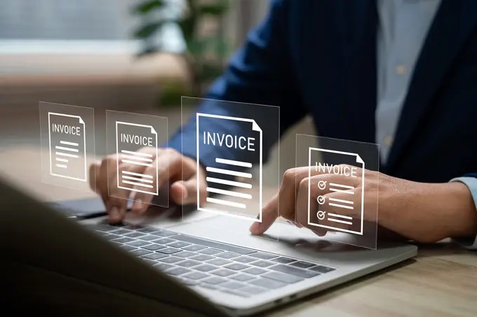 Hotel finance professional reviewing invoices on a laptop